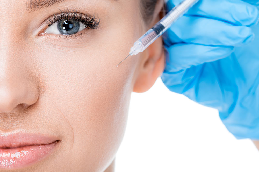 A woman having Botox injected into her cheek