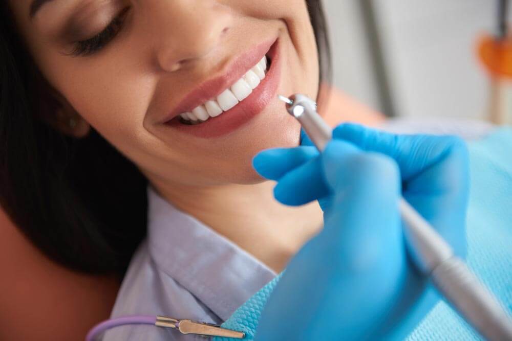 Dentist in sterile gloves doing professional teeth cleaning